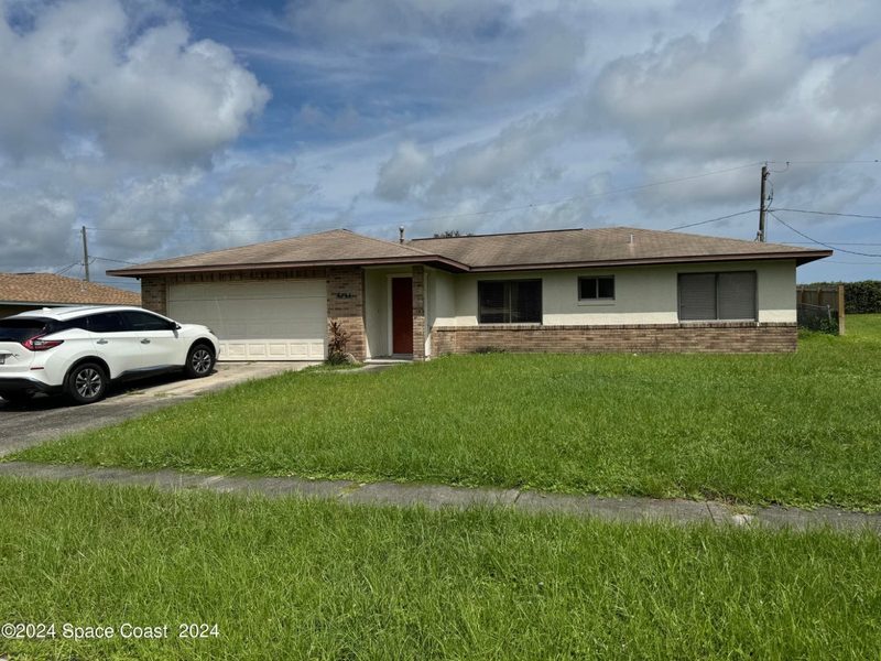 The Tackett home before we bought it: faded paint and an overgrown yard