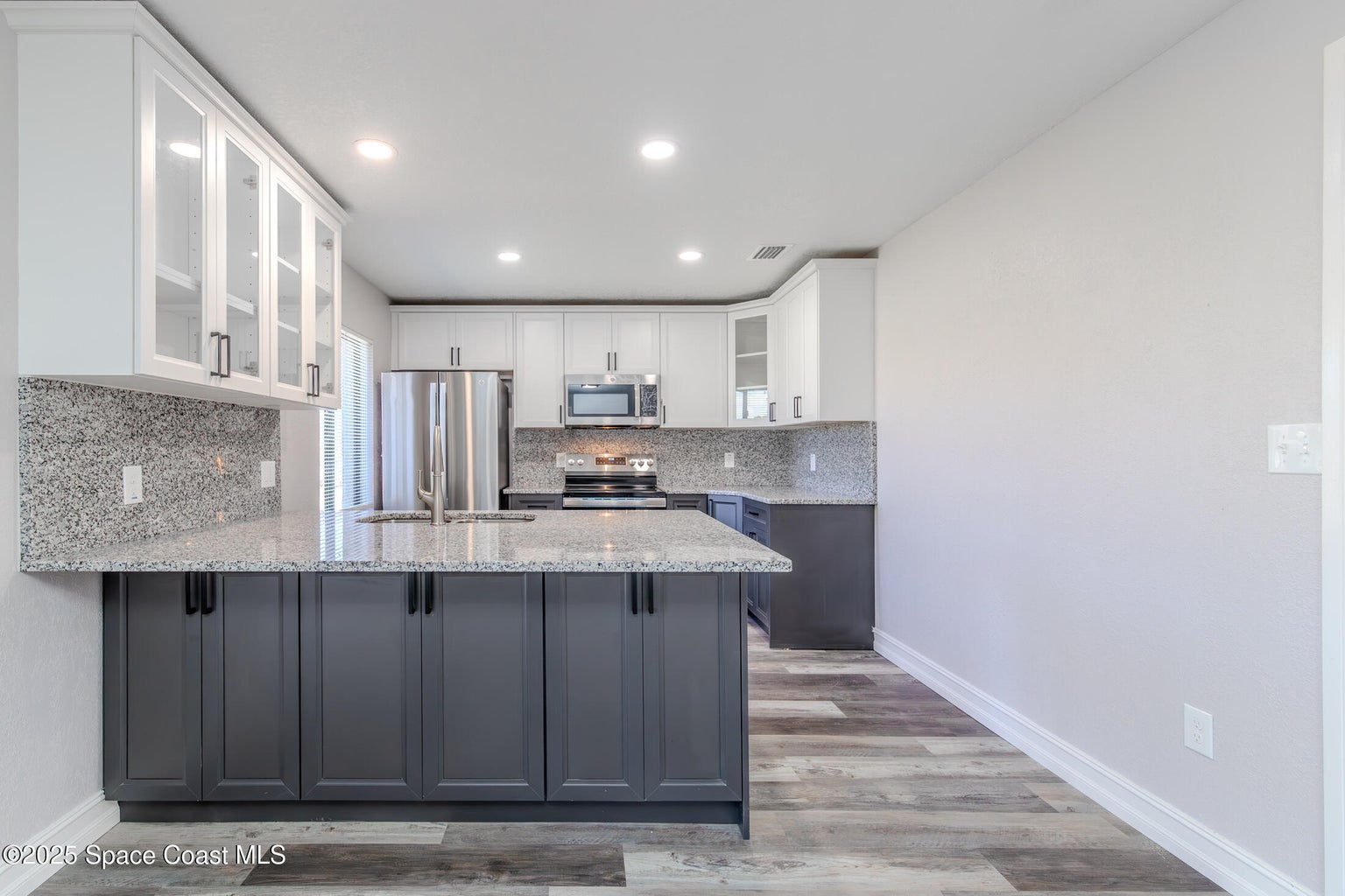 Tackett kitchen after — bright white cabinets, new counters, clean finishes